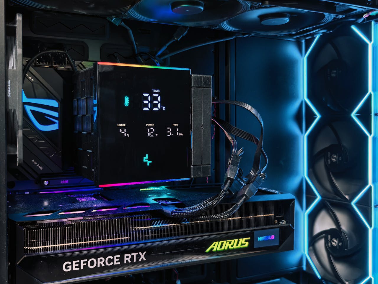about-us Detailed view of a gaming PC interior featuring an AORUS graphics card and RGB lighting setup.